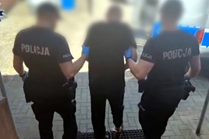 Zatrzymany mężczyzna prowadzony przez policjantów
