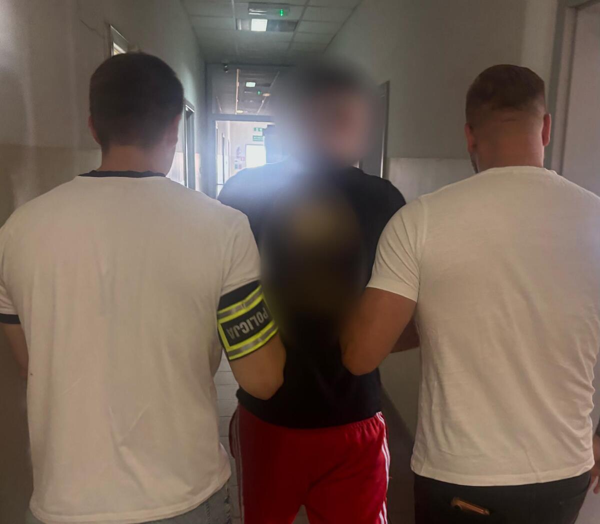 zatrzymany prowadzony przez policjantów