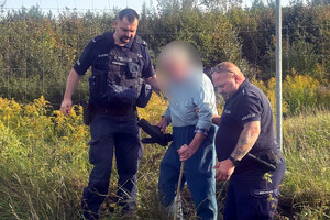 Mężczyzna prowadzony przez policjantów