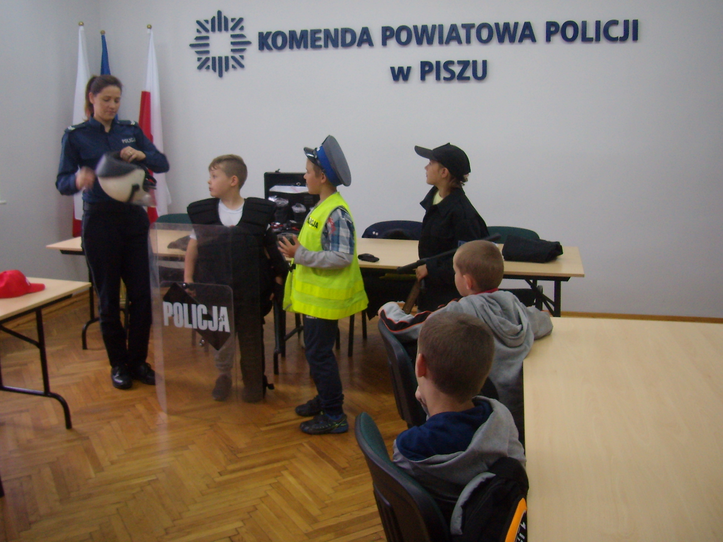 Policjantka prezentuje dzieciom wyopsażenie policyjne